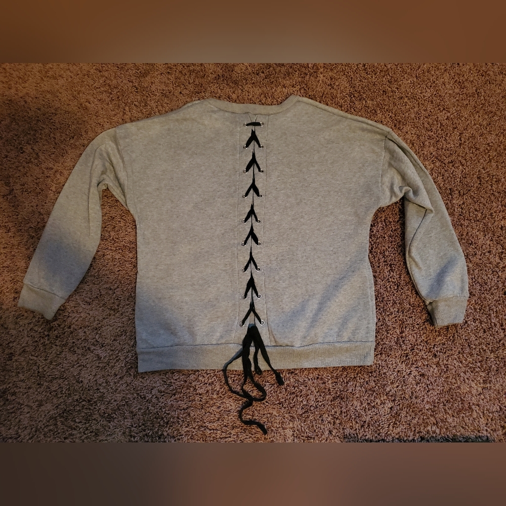 Gray sweater with black criss cross tie detaol